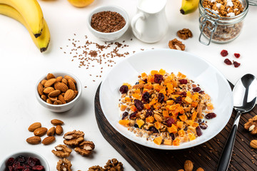 Healthy breakfast. Granola muesli with milk, dried apricots, cranberries, almonds and flax seeds. Clean eating, diet, detox, vegetarian food.