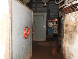 Abandoned prison in underground bunker. Ghost of prisoner. Ex Soviet cold war bomb shelter. Hermetic doors of bunker. Pipes and valves. Low light condition. Bunker of fear and nightmares.