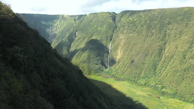 Majestic lush valley with huge steep walls and waterfalls, aerial