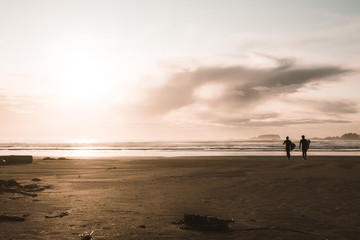 Fototapeta na wymiar silhouette of surfers on beach at sunset