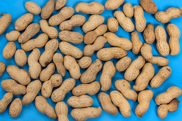 Pattern of peanuts on a blue background. Flat lay. Minimal background texture of food nut. Creative layout