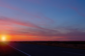 sunset road on a background of colorful sky