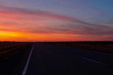 Fototapeta na wymiar sunset road on a background of colorful sky