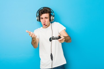 Teenager caucasian man using headphones and game controller © Asier