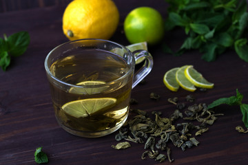 green tea with lemon and fresh mint on wooden background. healthy lifestyle.
