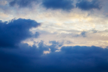 Fototapeta na wymiar Dark clouds in the evening sky in the sun's rays_