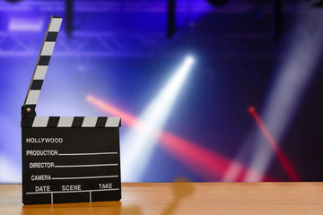 Illuminated Movie Camera With Clapperboard And Film Reel Against Colored Background