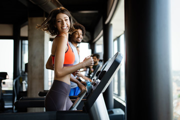 Fototapeta na wymiar Group of young people running on treadmills in modern sport gym
