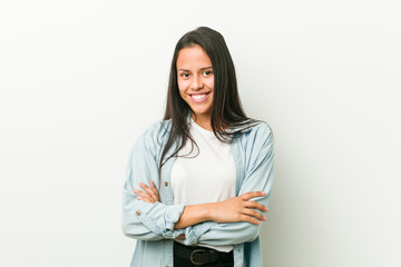 Young hispanic woman who feels confident, crossing arms with determination.