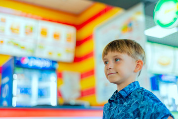 Fototapeta na wymiar A boy on children's rides in a shopping center.