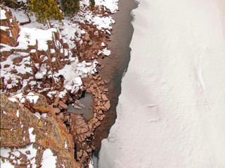 TOP DOWN: Couple relaxes in a hot spring in the middle of the snowy wilderness.