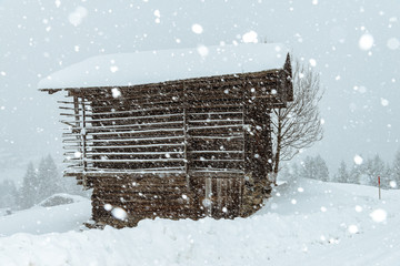 wooden cabin in the austrian alps, covered with snow