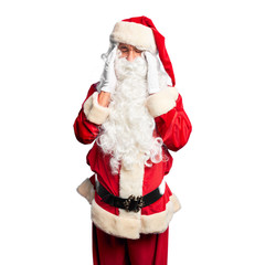 Middle age handsome man wearing Santa Claus costume and beard standing with hand on headache because stress. Suffering migraine.