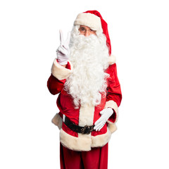 Middle age handsome man wearing Santa Claus costume and beard standing showing and pointing up with fingers number two while smiling confident and happy.