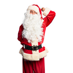 Middle age handsome man wearing Santa Claus costume and beard standing smiling confident touching hair with hand up gesture, posing attractive and fashionable