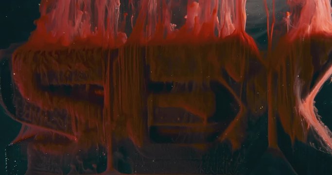 Text SEX. Art Colourful Object in Liquids. Macro.