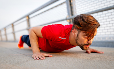Fototapeta premium Handsome fit man warming up before jogging outdoor