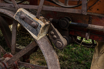 Bremse eines historischen landwirtschaftlichen Fahrzeugs, einer Dreschmaschine, bestehend aus  Bremsklotz aus Holz, Rad aus Stahl und Betätigungsgestänge aus Stahl