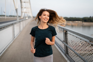 Portrait of fit and sporty young woman jogging outdoor