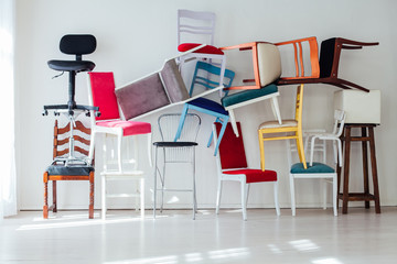 many multicolored chairs in the mess of the white room