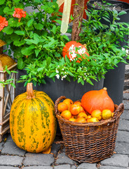 Amazing fall street decoration. Wooden lamp, squash, orange pumpkins and wicker basket with fresh apples. Colorful autumn decor, season of the year. Halloween backgrounds