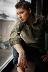Fototapeta premium Portrait of man looking through the window