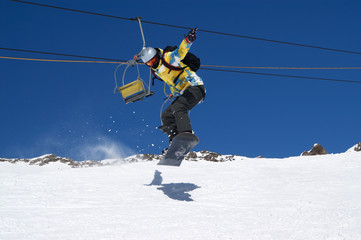 Fototapeta na wymiar Snowboarder jumping on snowy ski slope