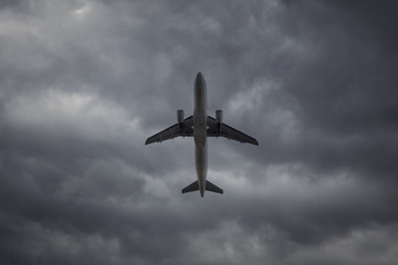 A passenger plane in the cloudy sky. Commercial plane taking off on background of storm clouds,...