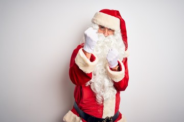 Middle age handsome man wearing Santa costume standing over isolated white background Ready to fight with fist defense gesture, angry and upset face, afraid of problem