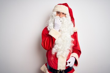 Middle age handsome man wearing Santa costume standing over isolated white background looking stressed and nervous with hands on mouth biting nails. Anxiety problem.