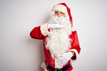 Middle age handsome man wearing Santa costume standing over isolated white background cutting throat with hand as knife, threaten aggression with furious violence