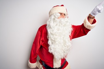 Middle age handsome man wearing Santa costume standing over isolated white background Pointing with finger surprised ahead, open mouth amazed expression, something on the front