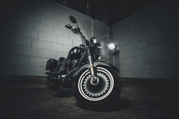 Amazing brand new motorbike is standing on the dark underground parking.