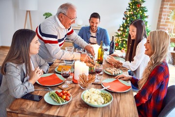 Beautiful family meeting smiling happy and confident. Carving roasted turkey celebrating Christmas at home