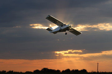 Small private single-propeller plane against the dramatic sky  - digital manipulation.