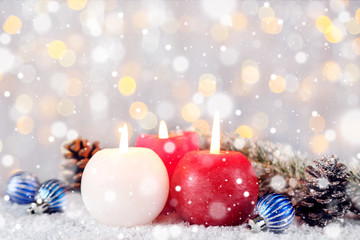 Christmas candles with baubles and fir tree branches on blurred background