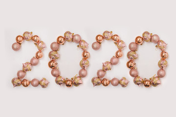 the figure 2020 is lined with Christmas balls in pink gold