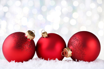 Christmas baubles with white snow on blurred background