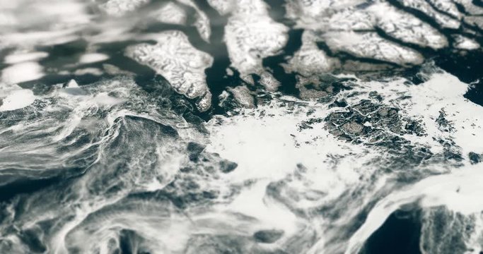 Very high-altitude circular tracking shot of ice in the Labrador Sea off Greenland's southern tip, with tilt-shift effect. Reversible, seamless loop. Elements of this image furnished by NASA