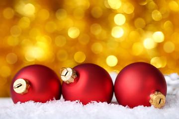 Christmas baubles with white snow on blurred background