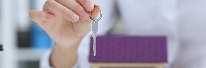 Female hand holds the key to the lock in the hand