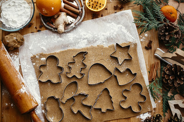 Making christmas gingerbread cookies, flat lay. Raw dough with metal cutters for cookies and wooden...
