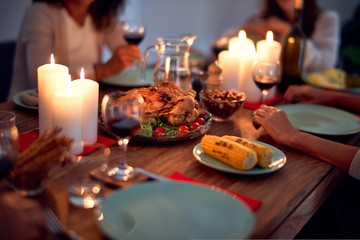 Family and friends dining at home celebrating christmas eve with traditional food and decoration, all sitting on the table together
