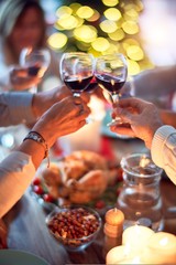 Family and friends dining at home celebrating christmas eve with traditional food and decoration, all sitting on the table together