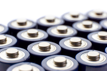 Batteries in rows. Close-up or macro of the positive poles of blue alkaline AA batteries. Image with selective focus isolated on top for copy space.  