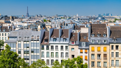 Fototapeta na wymiar Paris, typical buildings and roofs in the Marais, aerial view from the Pompidou Center, with the Eiffel Tower in background 