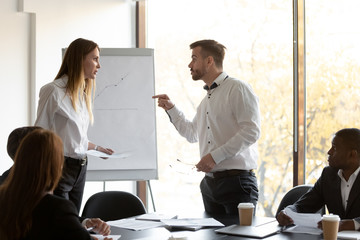 Angry male and female colleagues argue at corporate team meeting