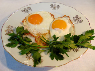 Scrambled eggs with greens on a plate close-up.
