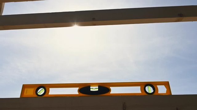 yellow bubble level checking wooden construction sky background