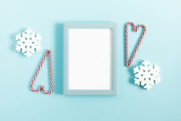 Christmas holiday composition. Photo frame, Xmas white and red decorations on pastel blue background. Christmas, New Year, winter concept. Flat lay, top view, copy space